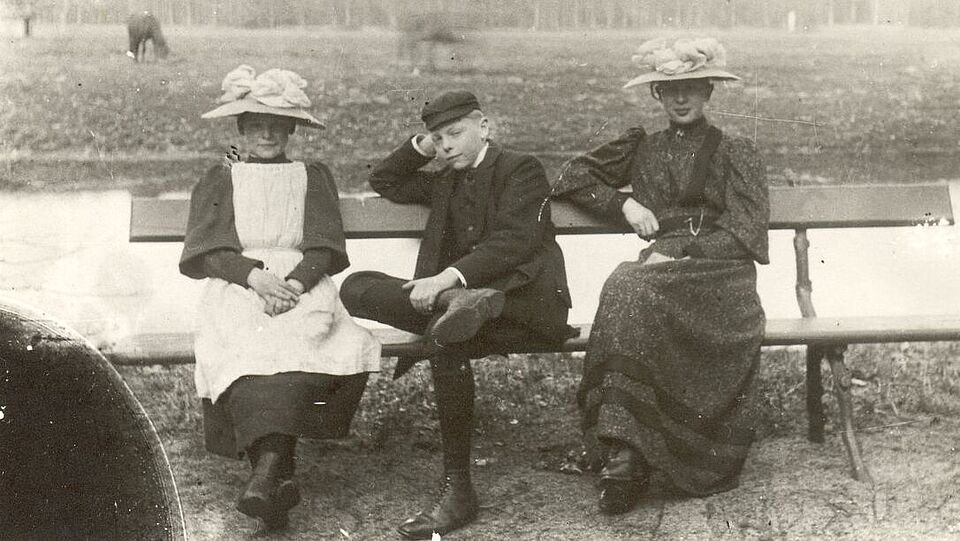 Foto van drie mensen op een bankje bij de Koewei, circa 1910.