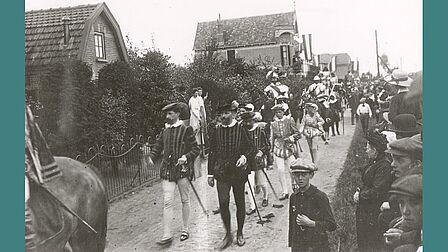 De optocht in de Spoorstraat, in het midden een persoon gekleed als Jan van Schaffelaar te paard